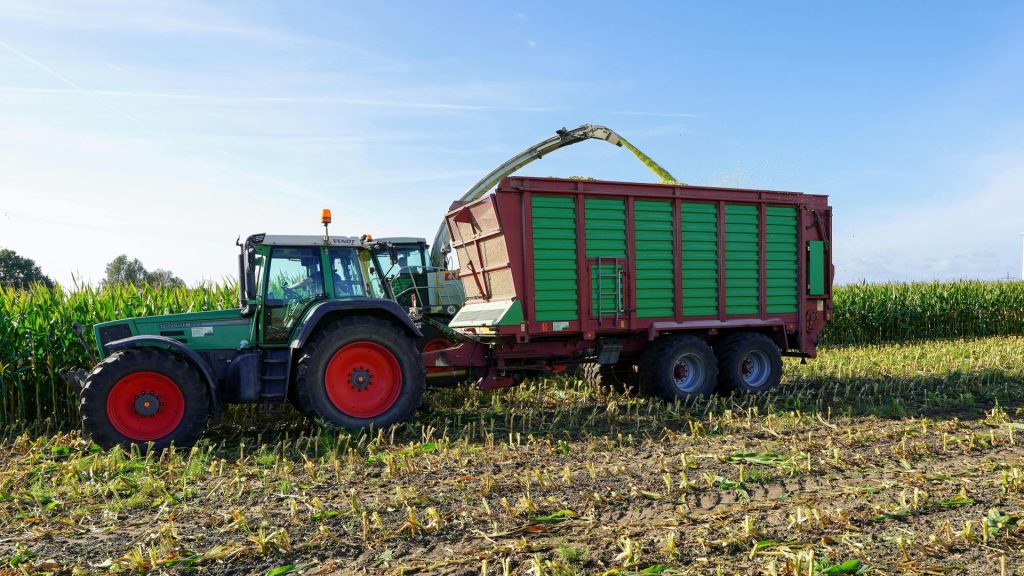 Traktor und Anhänger während der Maisernte in Hohnstorf, Deutschland.